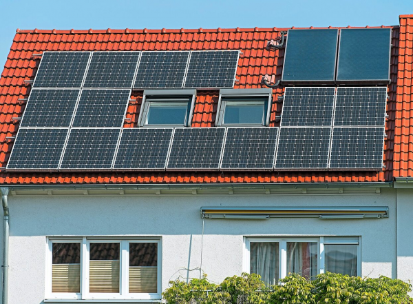 Auch kombinierbar: Solarthermie- und Photovoltaikzellen auf einem Dach. Foto: Anspach, dpa