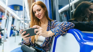 Mobile Games offline: Frau mit Handy in der U-Bahn